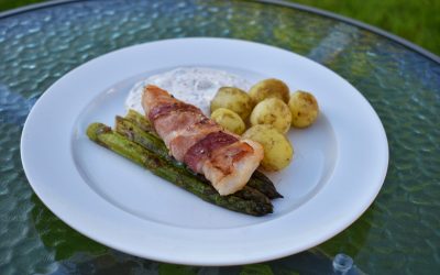 Baconlindad torskrygg med färskpotatis, stekt sparris och sås med stenbitsrom